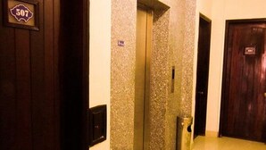Un couloir avec une porte en bois portant le numéro « 507 », un mur à texture et une poubelle.