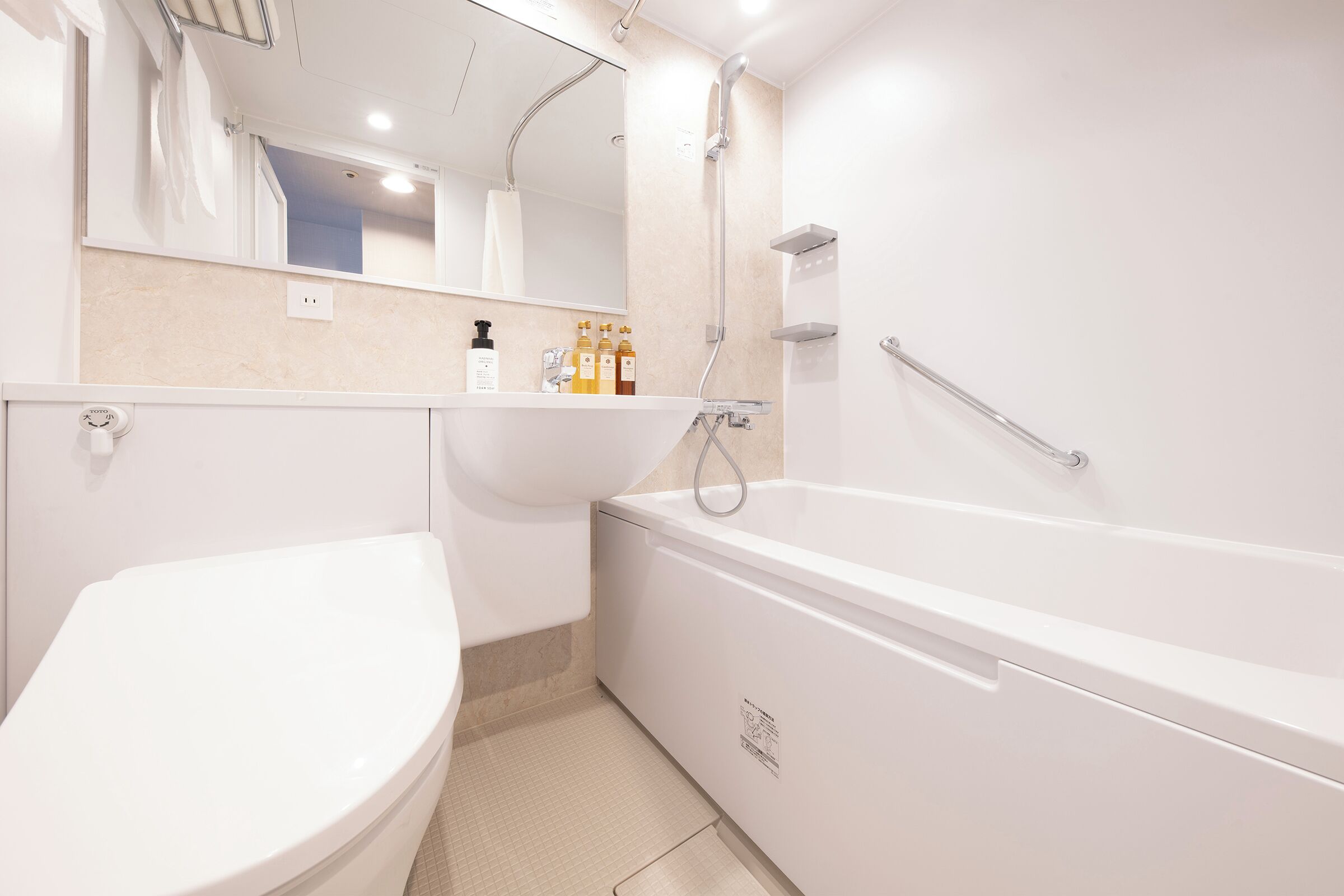 Une salle de bain moderne équipée de toilettes, d’un lavabo et d’une baignoire.