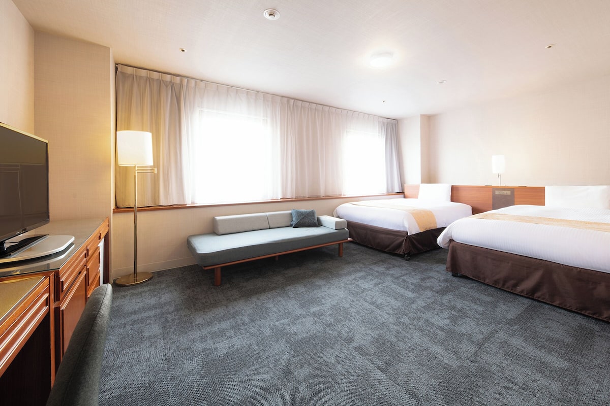 Habitación cuádruple superior, para no fumadores | Escritorio, espacio para trabajar con laptop y cortinas blackout