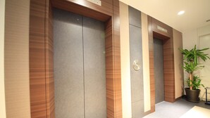 Un ascensor moderno con detalles de madera y una pantalla digital.