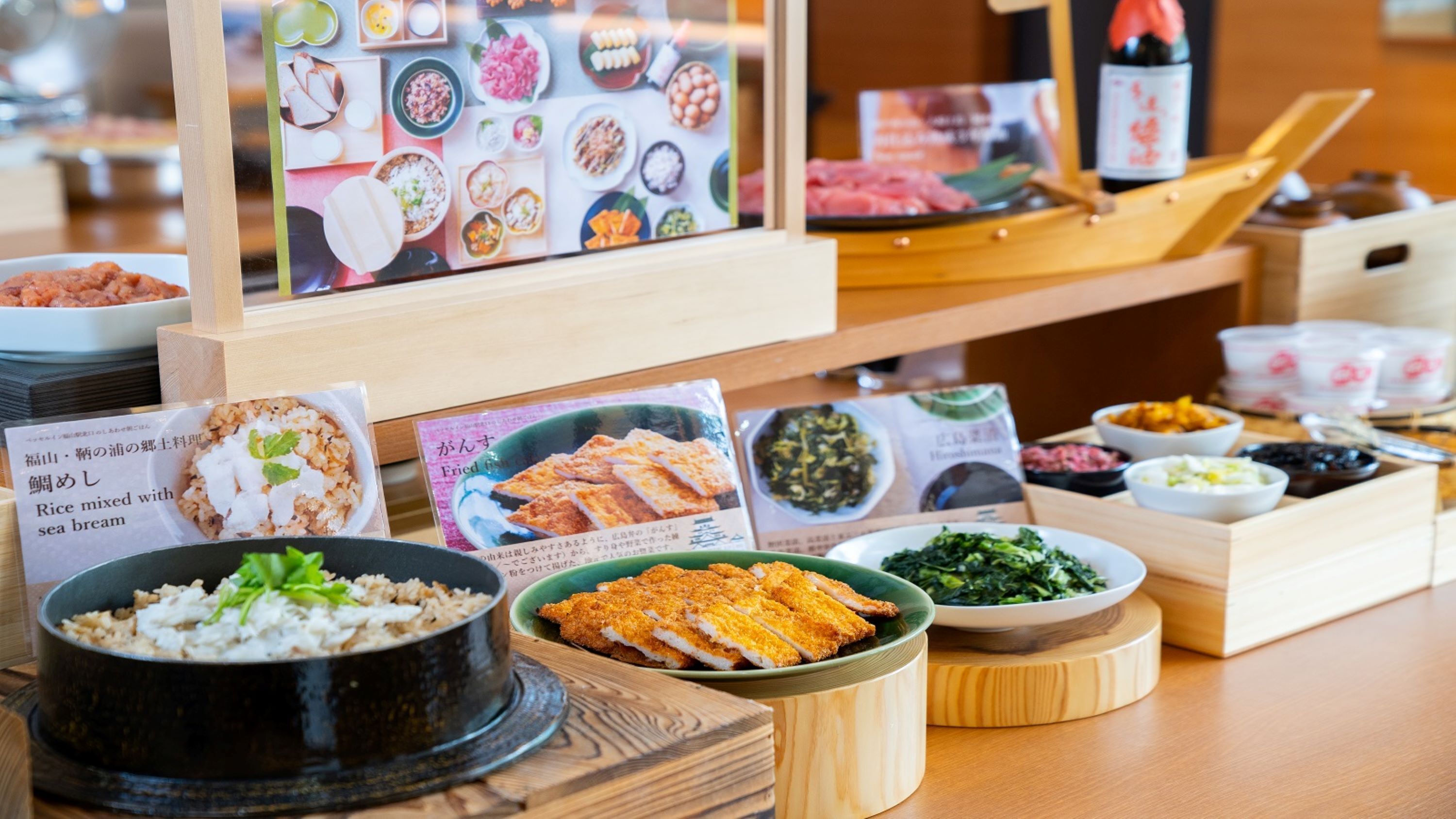 Une variété de plats japonais présentés sur une table en bois, avec des menus à disposition.
