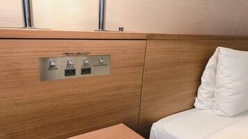 Un panel de madera con un tablero de control que tiene botones etiquetados 'ROOM', 'DESK', 'FOOT' y 'ENTRANCE'.
