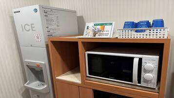 A kitchenette with an ice dispenser, a microwave, and a small refrigerator.