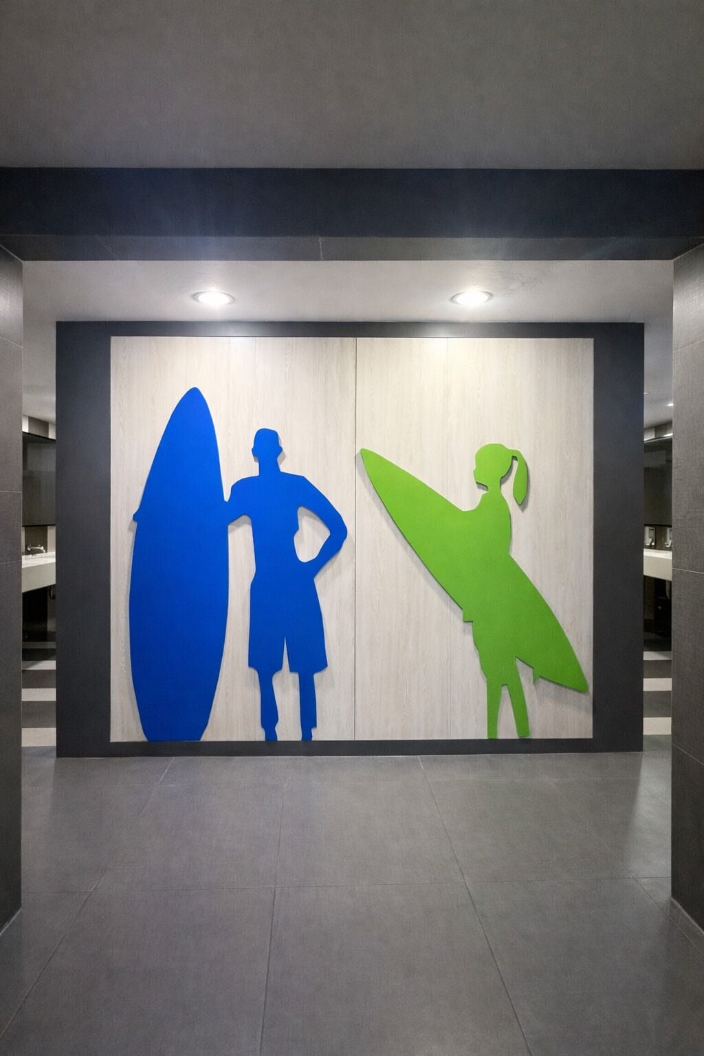 A modern interior with a wall-mounted artwork featuring silhouettes of two people with surfboards.