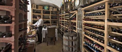 Une cave à vin avec des étagères et des rayonnages en bois remplis de bouteilles de vin.