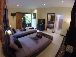 A hotel room with two beds, a TV, a desk, and a balcony with curtains. - Baan Sukreep Resort (Koh Samui)