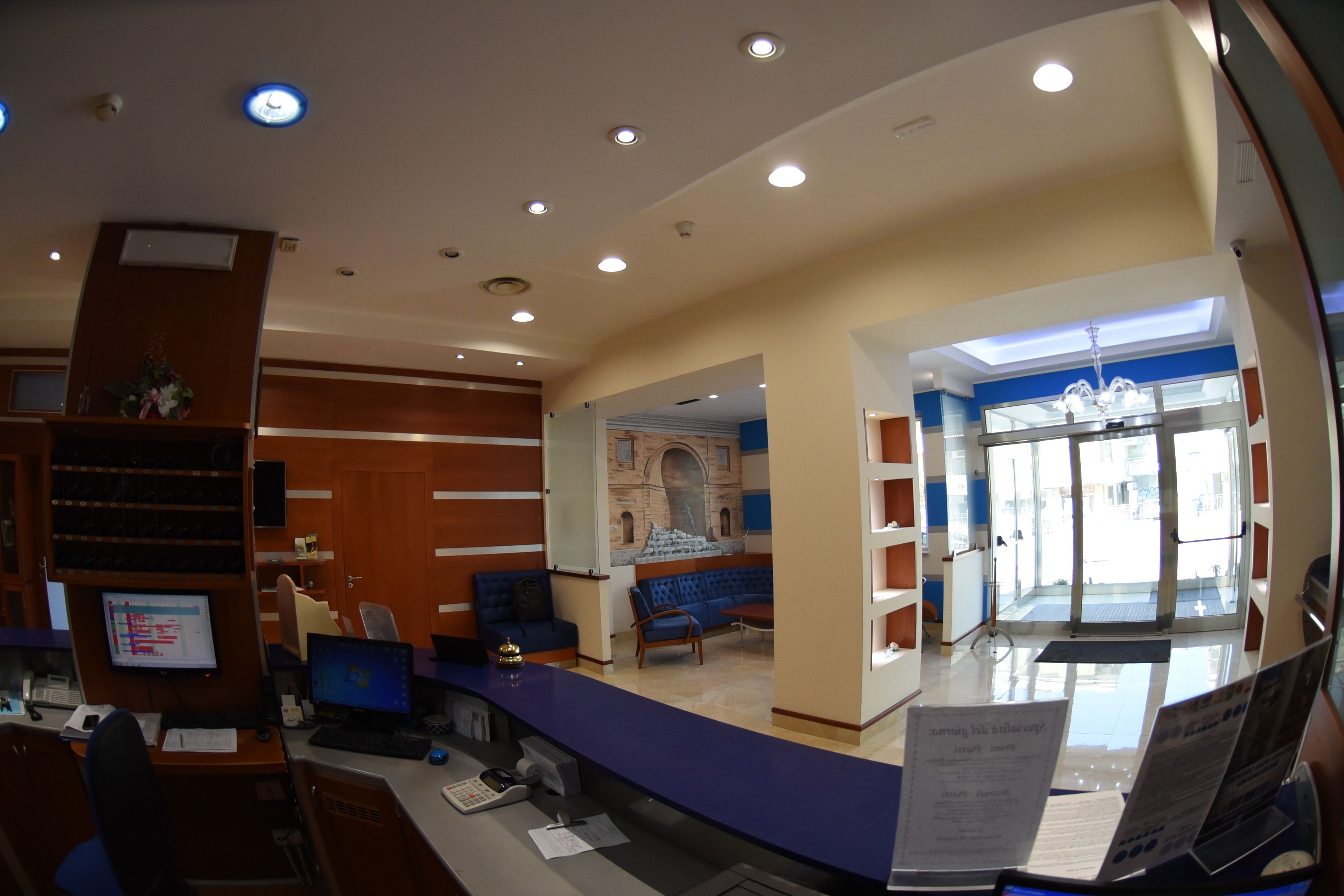 Zona de recepción con mostrador, asientos y vista al vestíbulo.