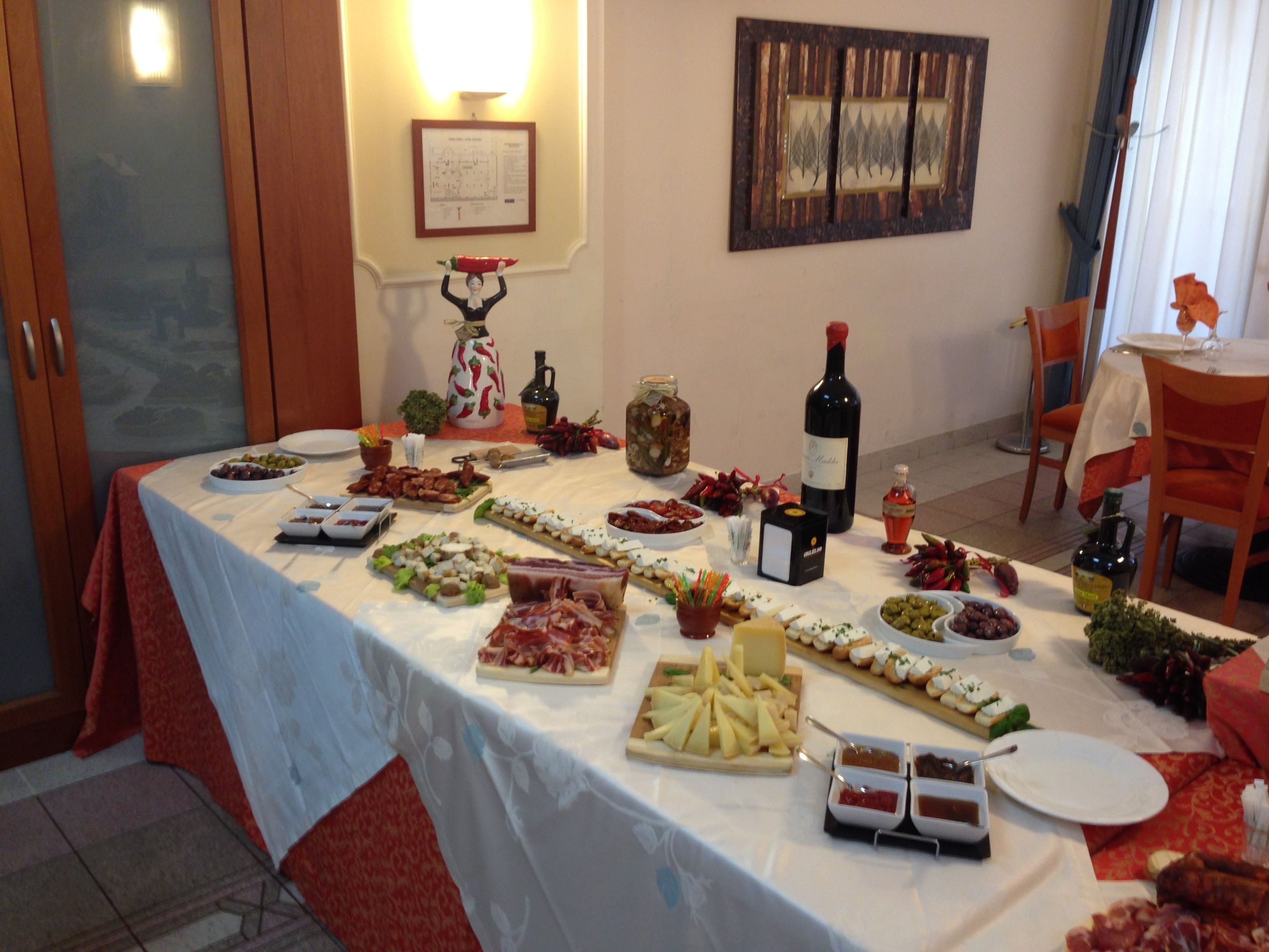 A table set with various food items and a bottle of wine, likely for a gathering or event.