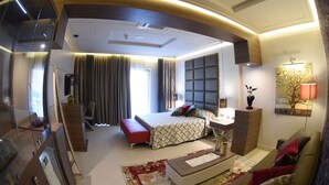 Une chambre d’hôtel moderne équipée d’un grand lit, d’un bureau, d’un canapé et d’une télévision.