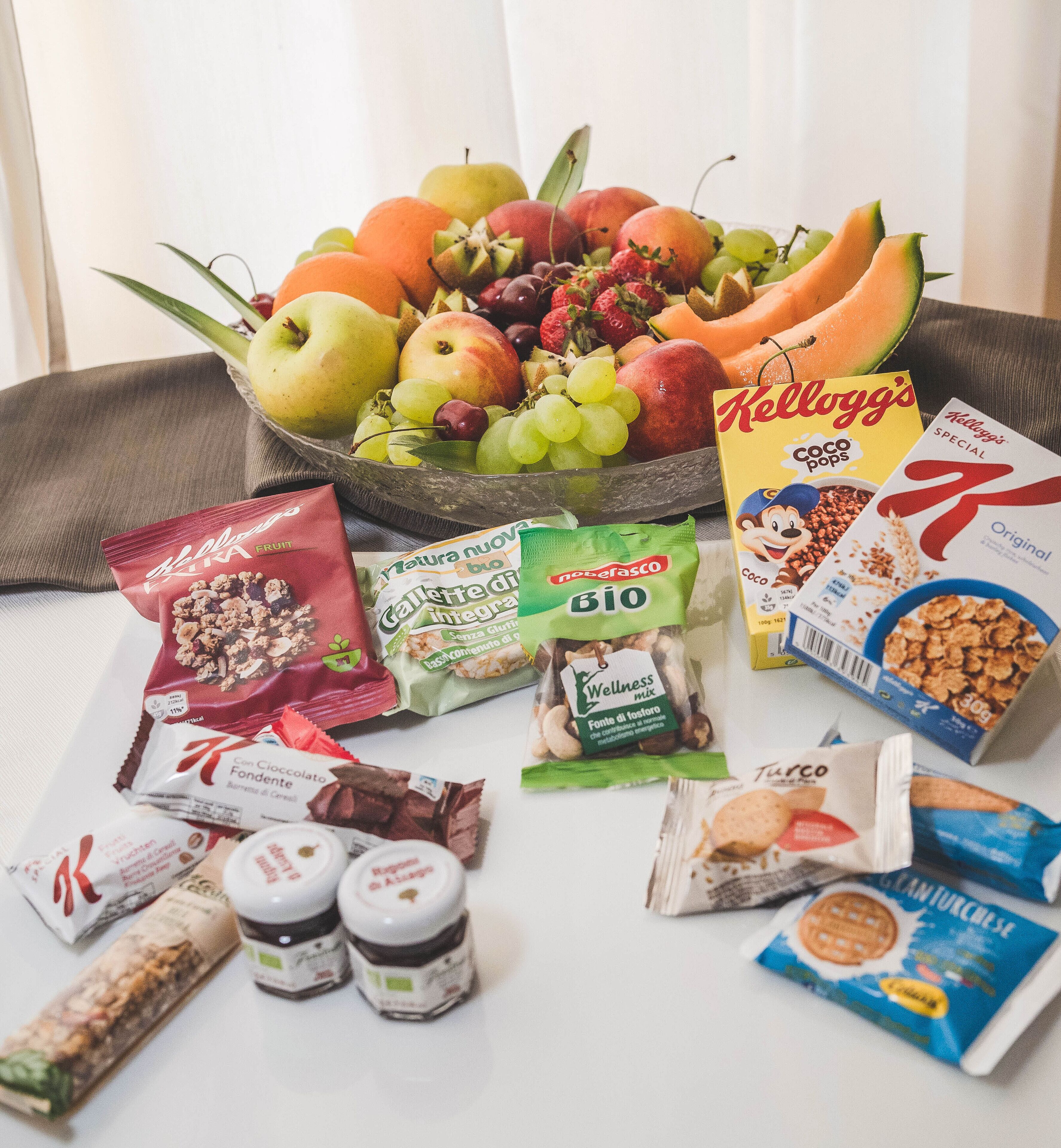 A variety of food items including fruits, cereals, and snacks arranged on a table.