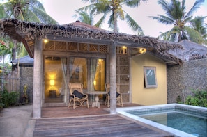 A thatched-roof outdoor lounge area with wicker furniture and a pool. - Les Villas Ottalia Gili Trawangan (Gili Trawangan)