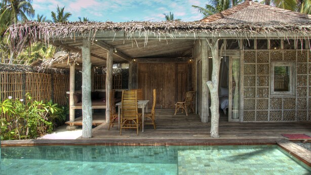A wooden structure with a thatched roof, a pool, and wicker furniture. - Les Villas Ottalia Gili Trawangan (Gili Trawangan)