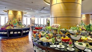 A buffet with various food items and a decorative centerpiece. - Hotel Prestige (Makkah)