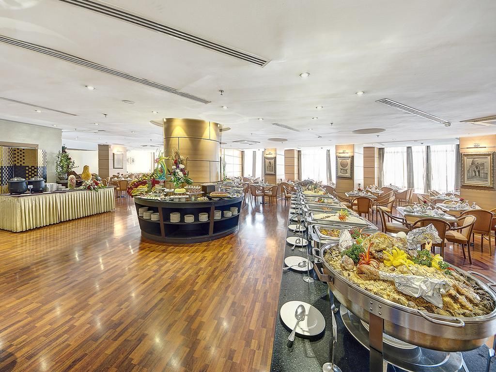 A buffet area with multiple serving stations, a central decorative column, and a variety of food options.