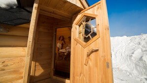 Une cabane en bois avec une porte ouverte, une fenêtre et un paysage enneigé en arrière-plan.