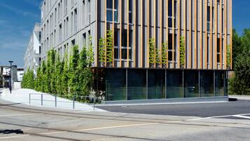 A modern hotel with a vertical facade, large windows, and a flat roof.