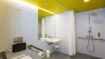 A modern bathroom with a white toilet, sink, and shower.