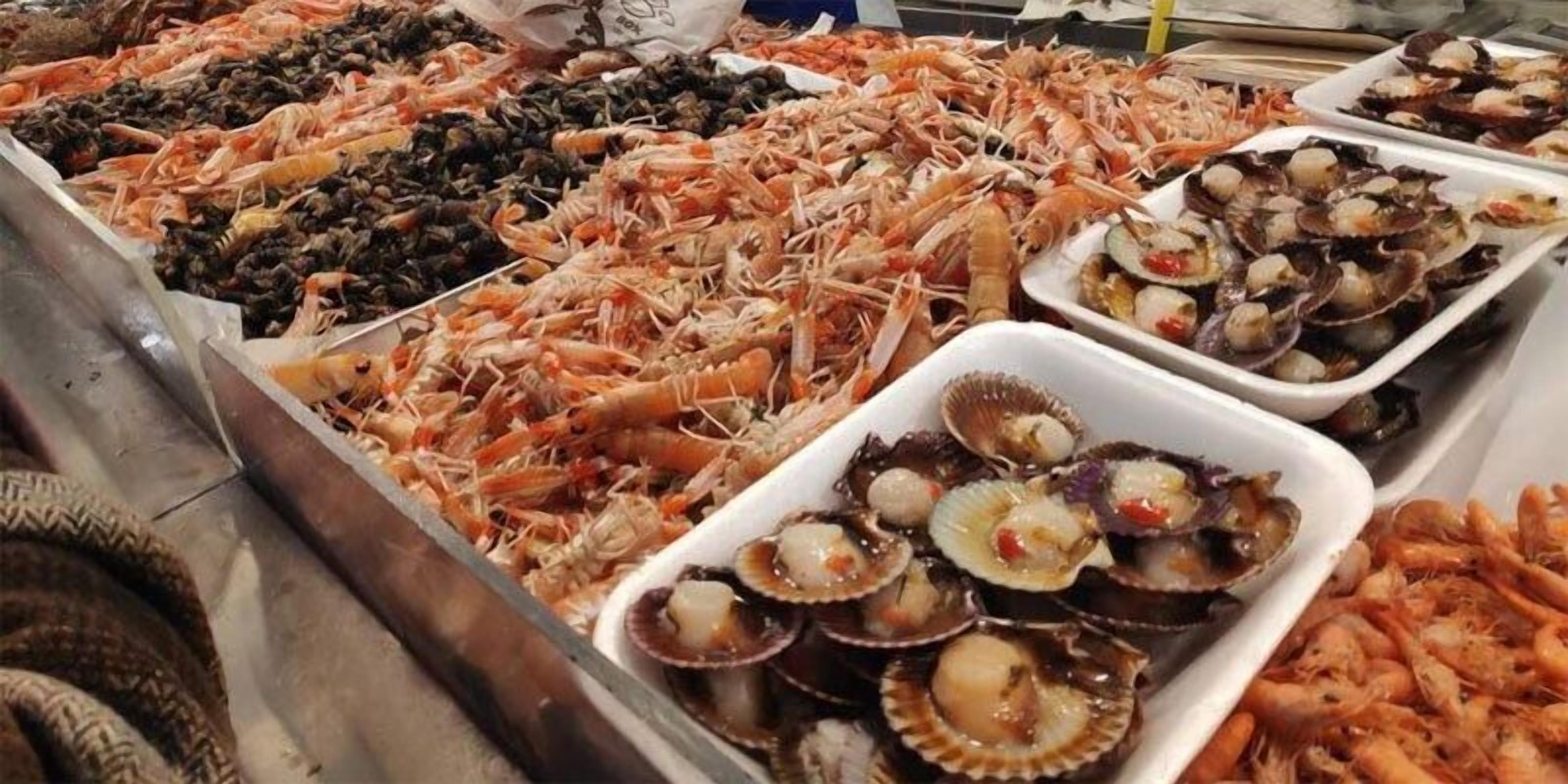A seafood display with various types of shellfish and prawns.