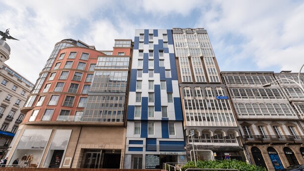 Une rangée de bâtiments modernes aux styles architecturaux variés, dont un bâtiment remarquable aux motifs bleus et blancs.