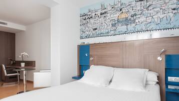 Una habitación de hotel moderna con una cama grande, un escritorio y una silla.