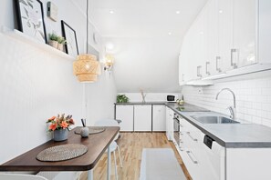 Familie appartement | Privékeuken | Een koelkast met diepvriezer, een microgolfoven, een vaatwasser
