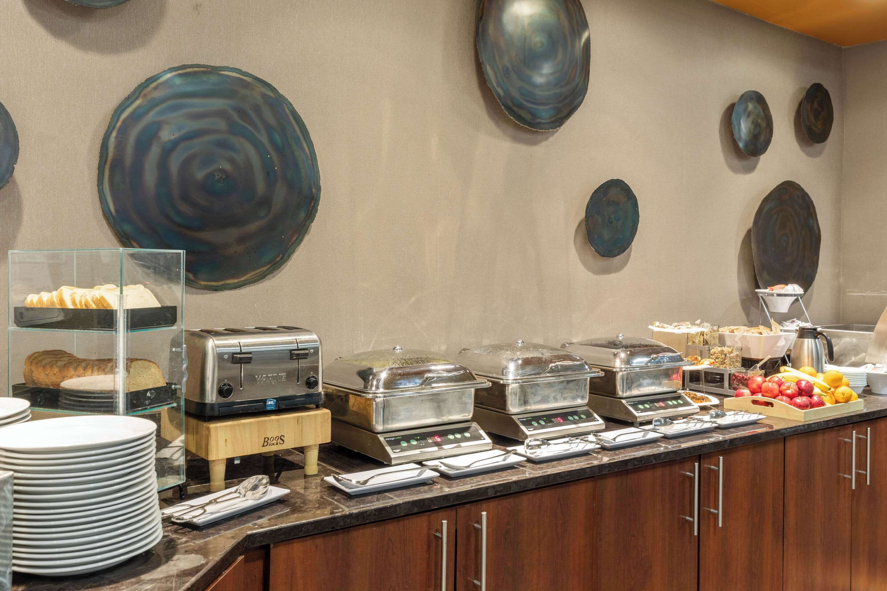 A buffet setup with various food items, a toaster, and a coffee maker.