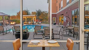 Ein Essbereich im Freien mit Blick auf einen Pool und Terrassenmöbel.