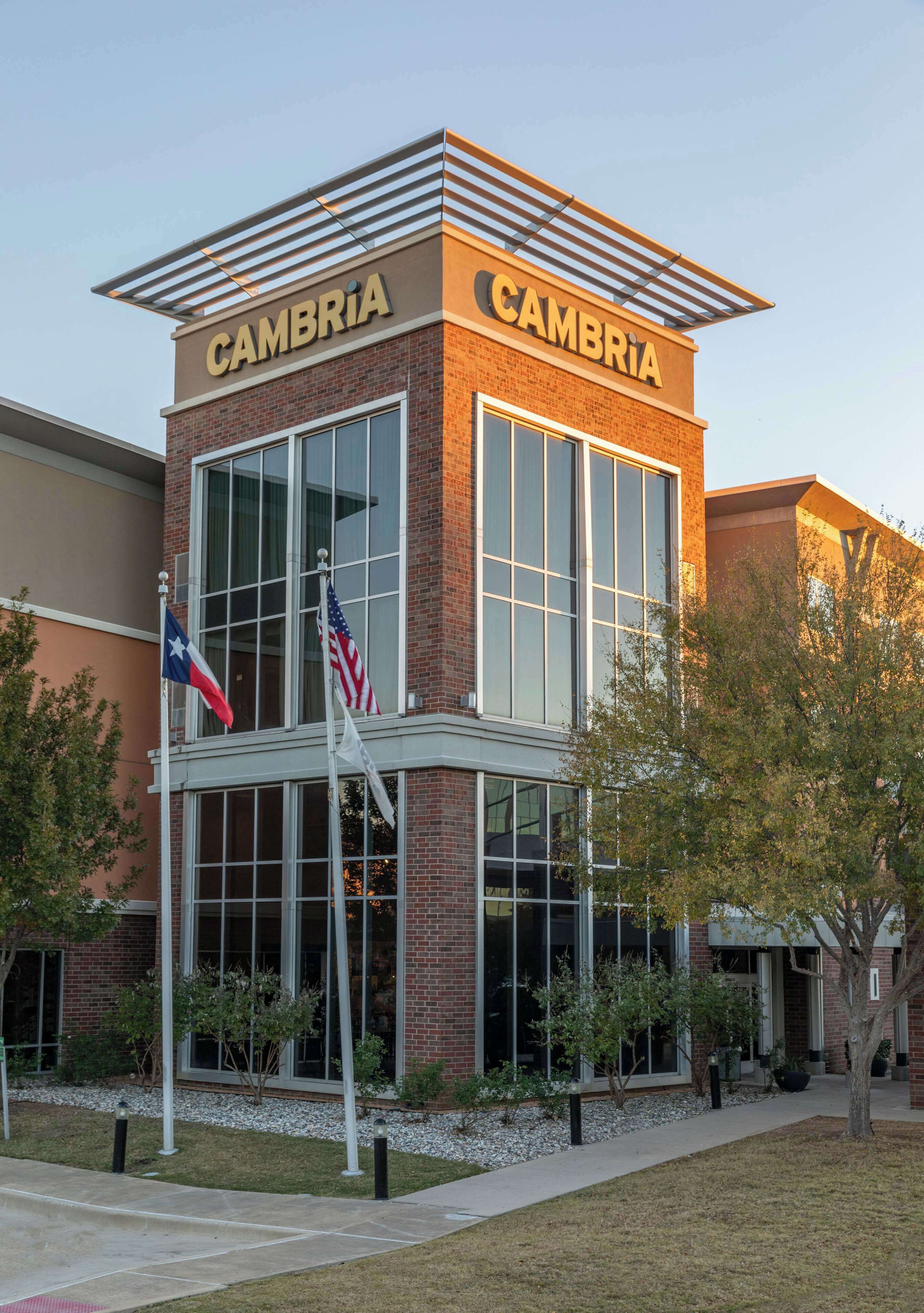 A building with the name 'CAMBRIA' on the facade, featuring large windows and a brick exterior.