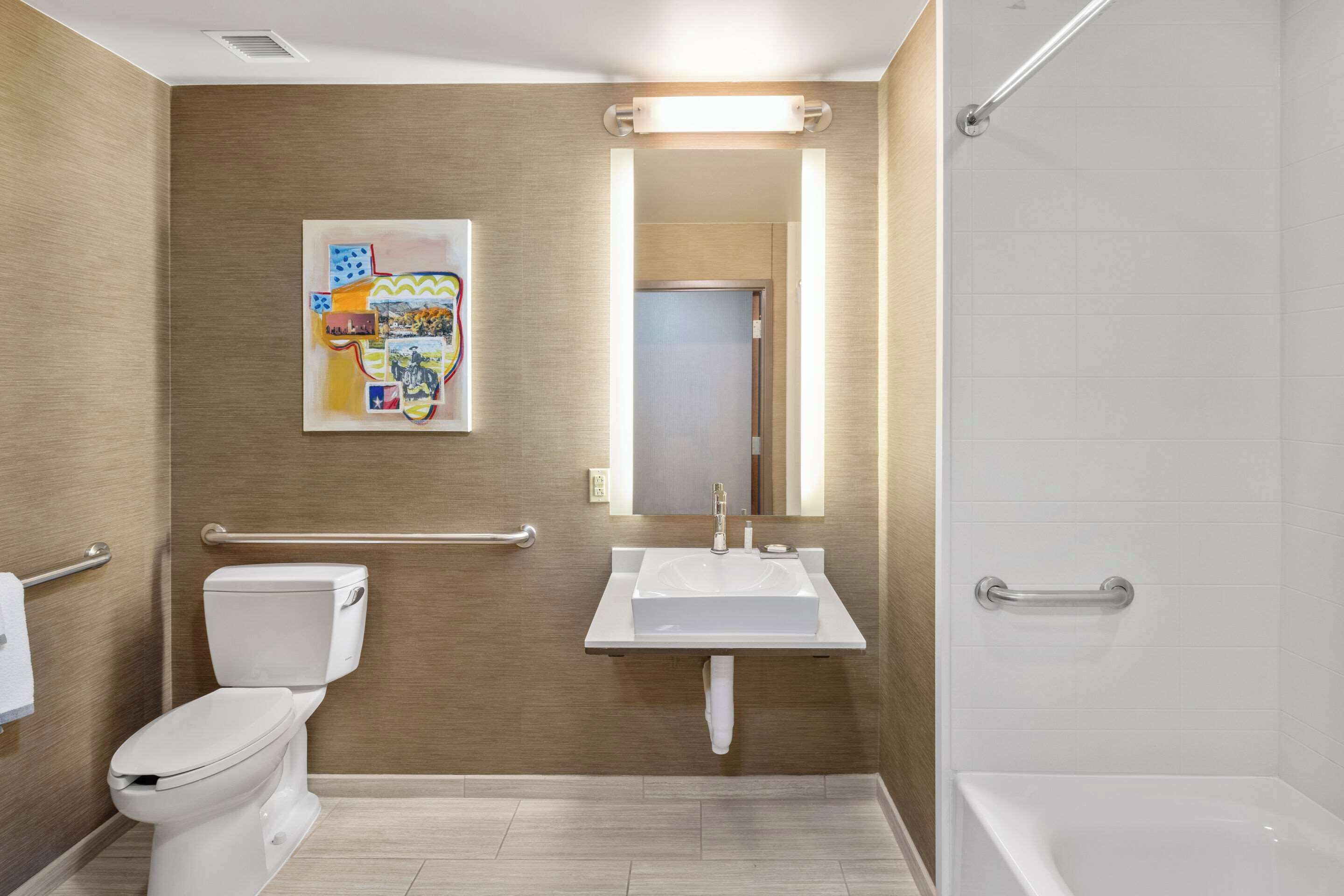 A modern bathroom with a toilet, sink, and shower.