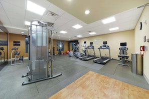 A gym with cardio machines, weight training equipment, and a wooden floor. - Hilton Garden Inn Lawton-Fort Sill (Lawton)