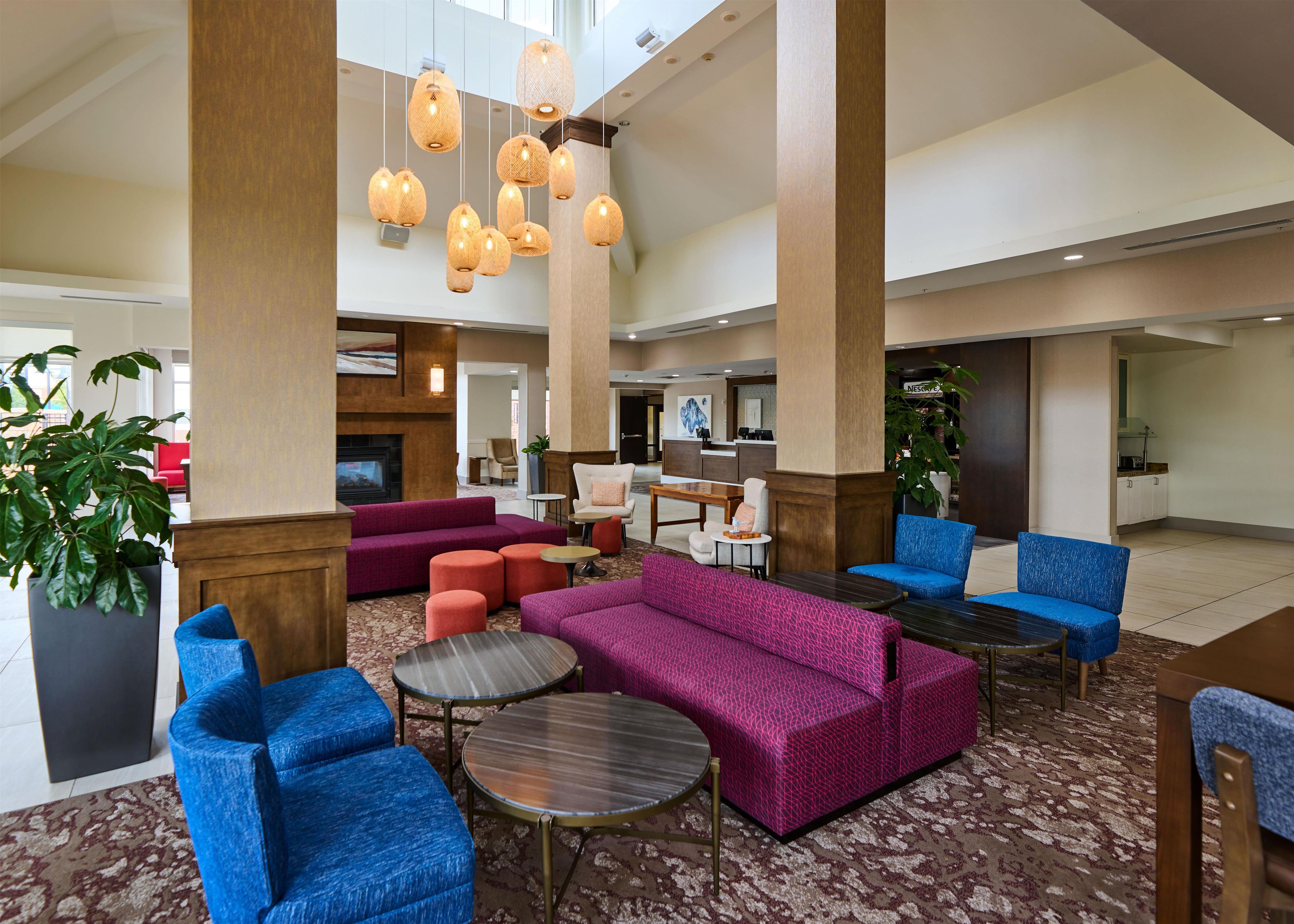 A spacious lobby with seating areas, a reception desk, and a fireplace.