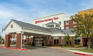 A Hilton Garden Inn with a covered entrance, brick facade, and a clear sky. - Hilton Garden Inn Lawton-Fort Sill (Lawton)