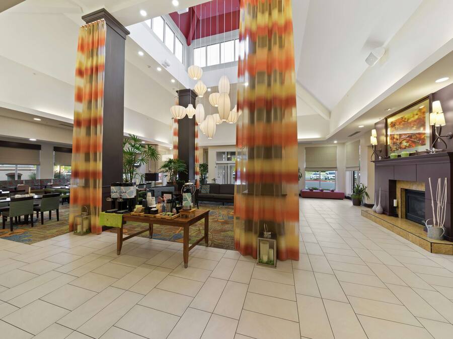 A spacious lobby with high ceilings, a central seating area, and a fireplace.