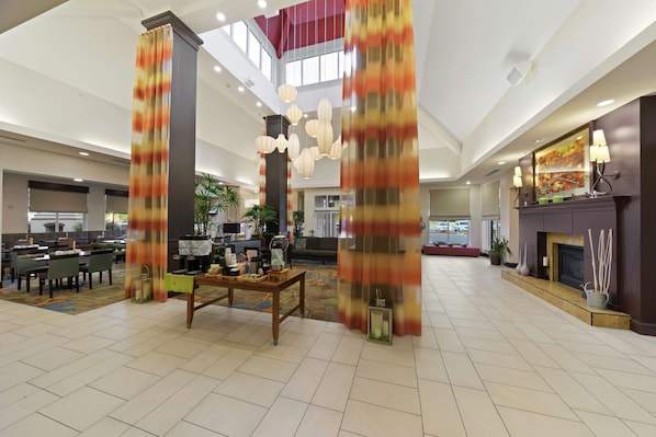 A spacious lobby with high ceilings, a central seating area, and a fireplace. - Hilton Garden Inn Lawton-Fort Sill (Lawton)