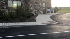 A building with a stone facade, a paved entrance, and a parking lot. - Hampton Inn Indianapolis NW/Zionsville (Whitestown)