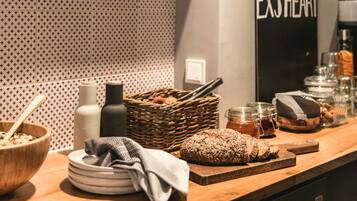 A kitchen counter with a wooden cutting board, a loaf of bread, a bowl, and various kitchen items.