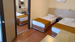 Una habitación de hotel con dos camas, un baño y una mesita de noche con lámpara.
