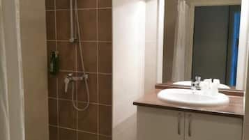 A bathroom with a shower, a sink, and a mirror.