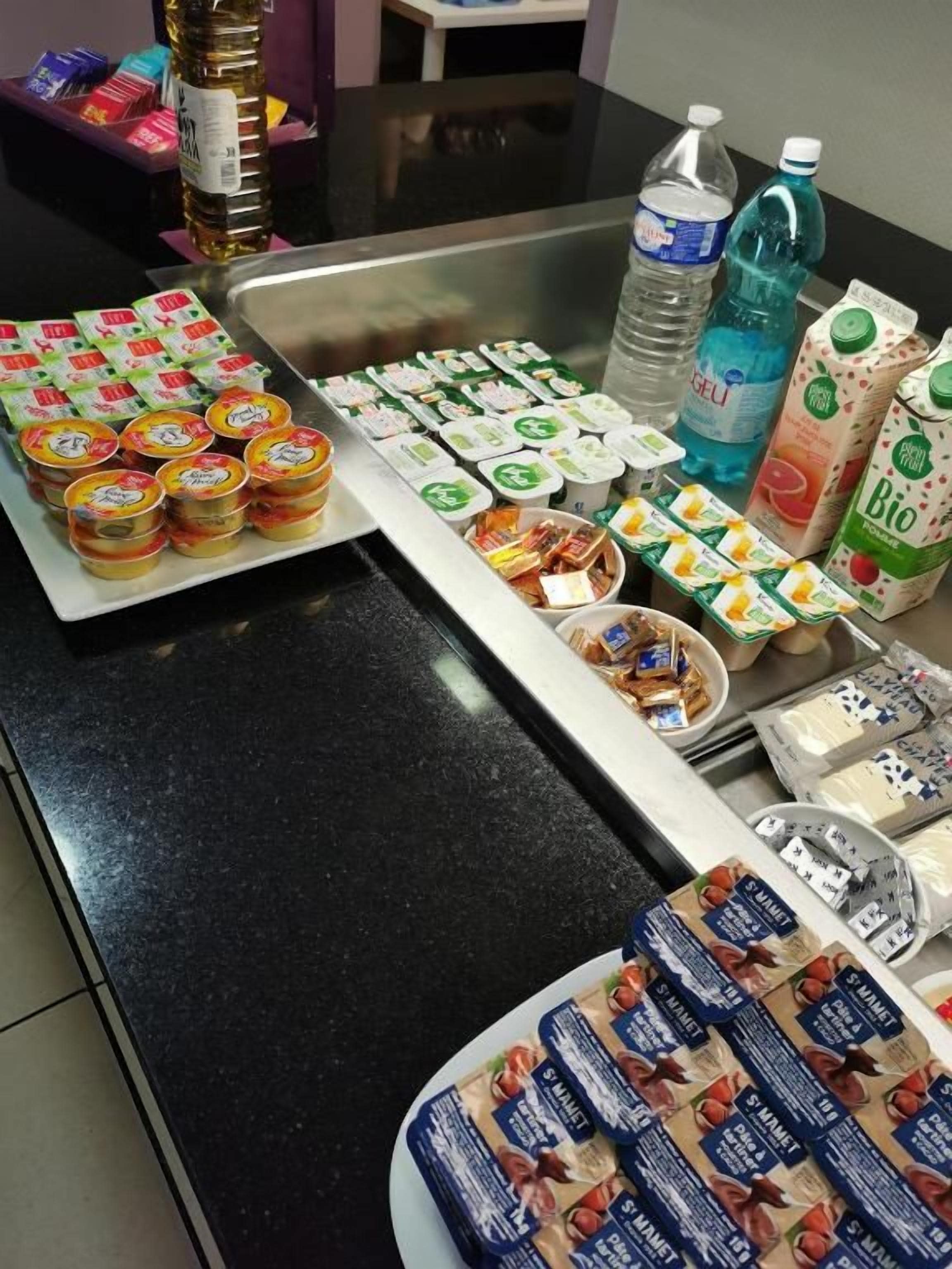 A buffet table with various food items and beverages.