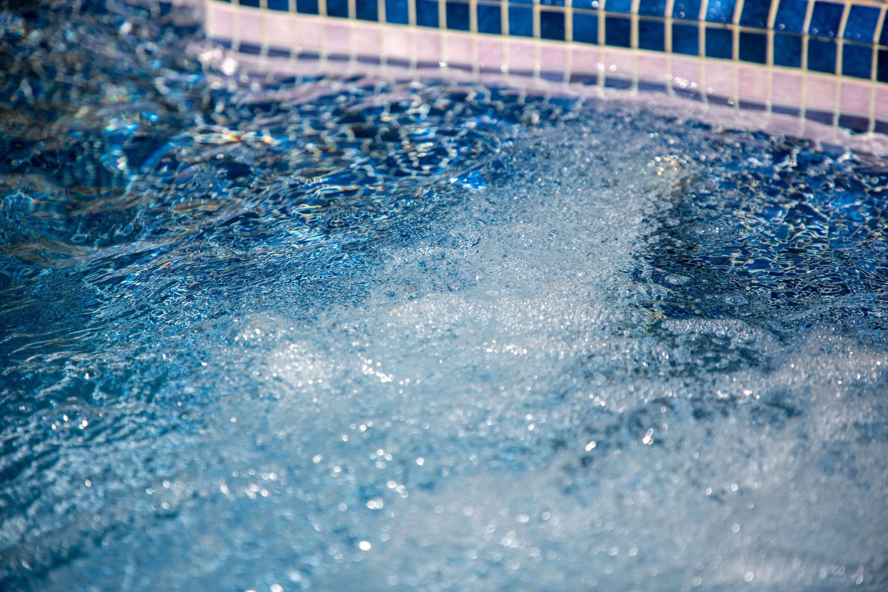 A close-up of water with bubbles, likely from a hot tub or spa.