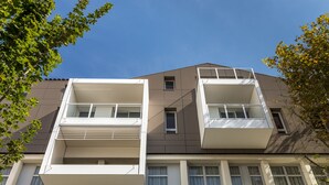 A modern building with two balconies, large windows, and a clear blue sky. - Privilège Appart Hotel Saint-Exupéry (Toulouse)