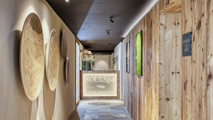 Um corredor com parede de madeira, balcão de recepção e uma placa com a inscrição "SOULSpa".
