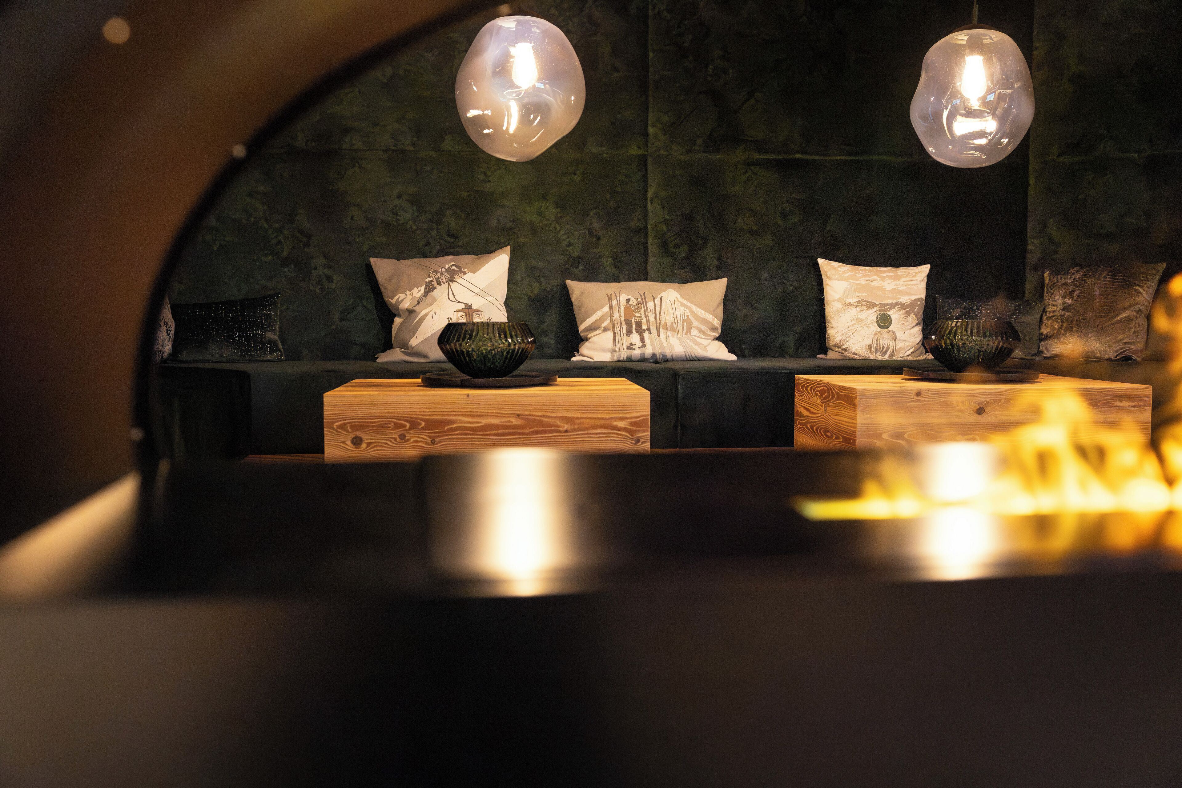 A cozy seating area with a sofa, cushions, and a bowl on a wooden table.