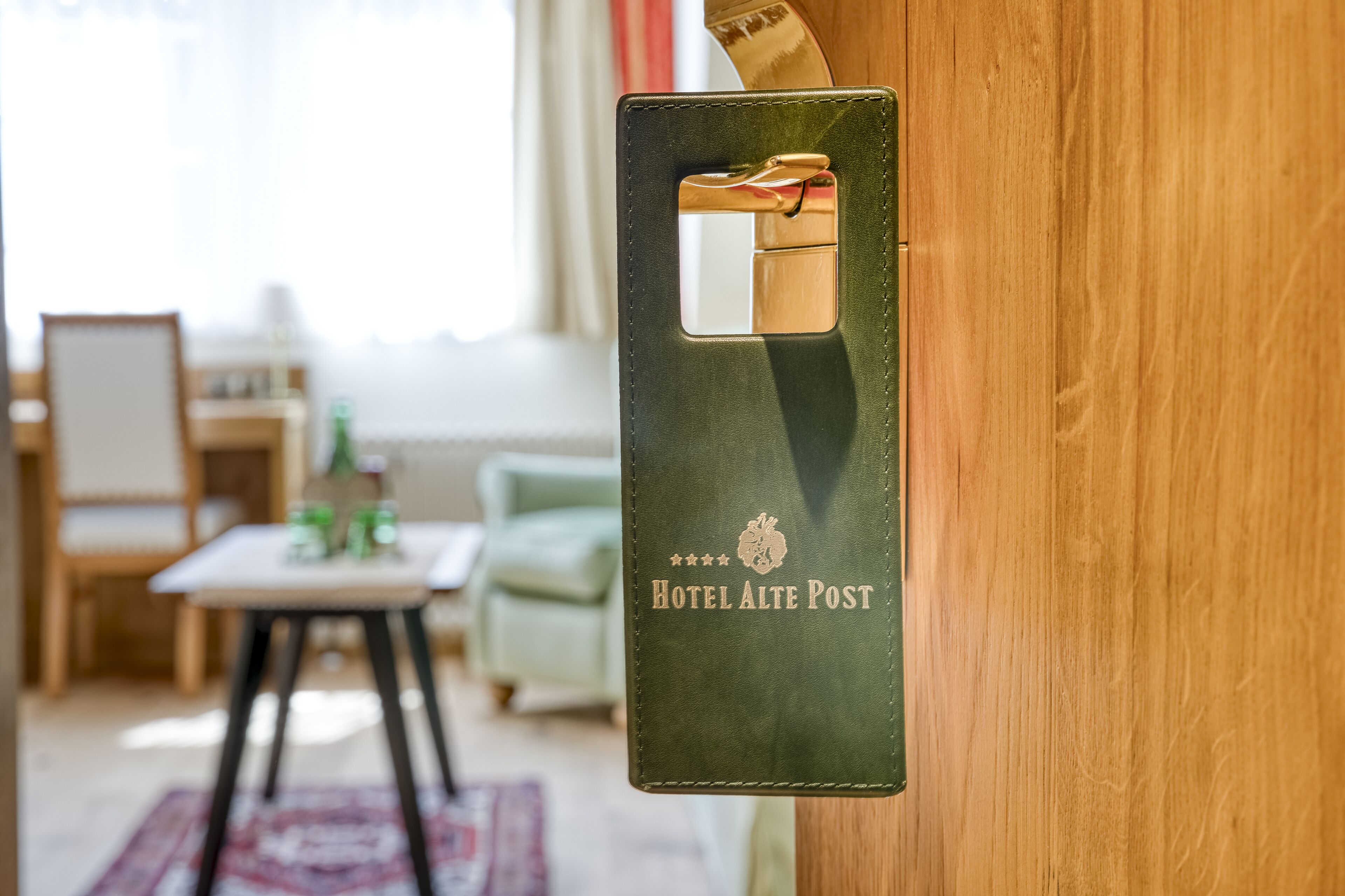 A door with a green leather keyhole and the text "Hotel Alte Post" on it.