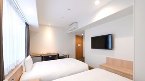 A hotel room with two beds, a desk, a chair, a television, and an air conditioning unit. - Vessel Inn Ueno Iriya Station (Tokyo)