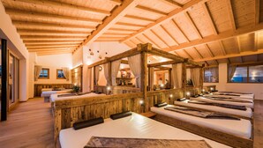 Habitación de hotel con vigas de madera, varias camas y un espejo grande.