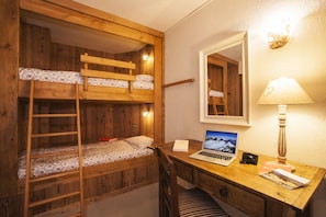 A bunk bed with a wooden ladder, a desk with a laptop, a camera, and a lamp. - Hotel Ruitor (Arvier)