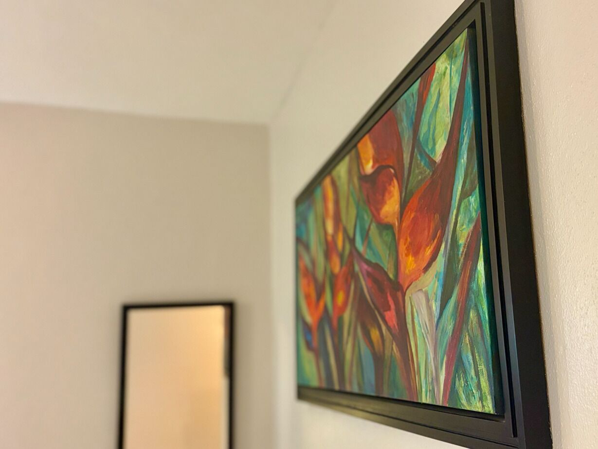 Ein gerahmtes, abstraktes Gemälde an einer Wand.