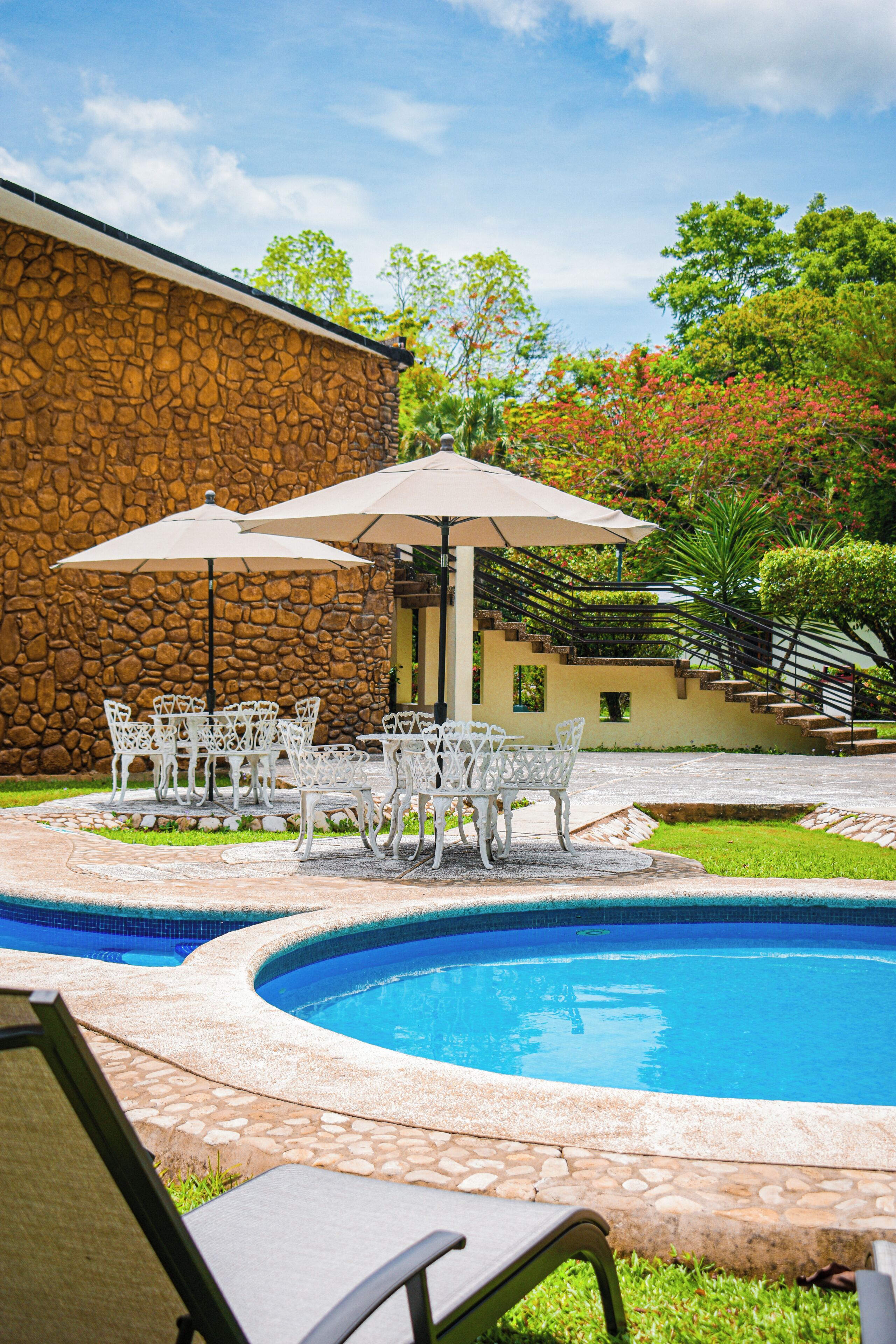 Alberca al aire libre, sombrillas en la alberca y camastros 