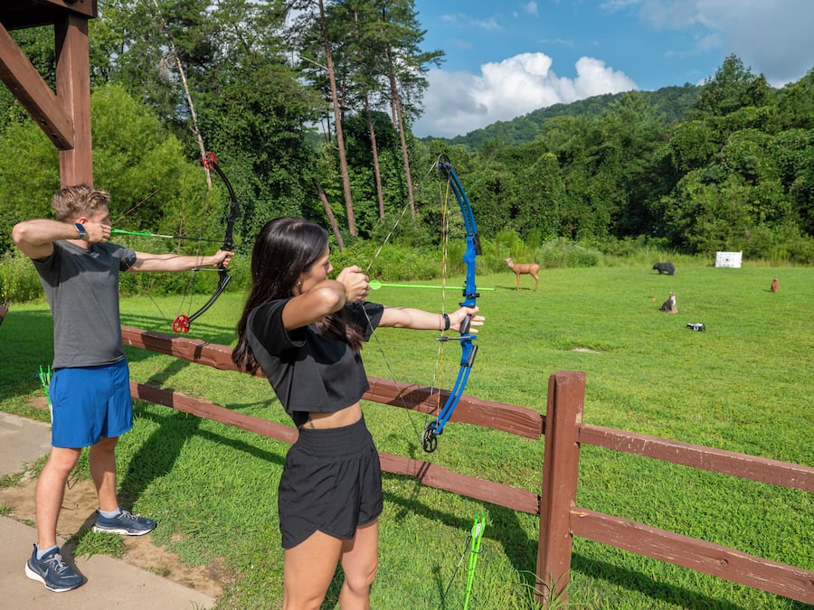 An outdoor archery range with targets and a wooden fence.